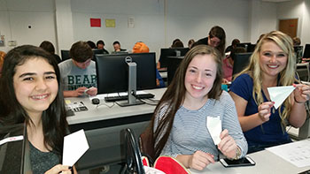 Three students folding