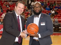 Jason Henderson Athletics Director and Alumni Board Member Chris Bates presents game ball.