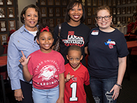 Phyllis, Peyton, and Maxwell Thibodeaux with Evie Clifton at Alumni Between the Games Party
