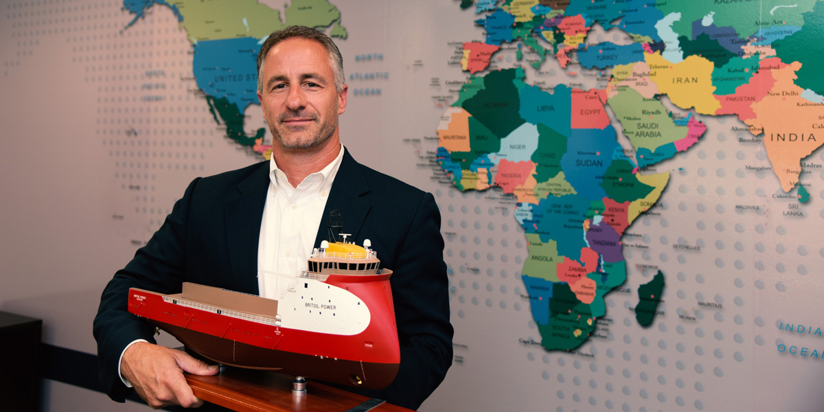 Anthony George poses with a model tugboat