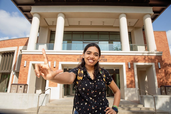 One student in front of Setzer Center making L with fingers