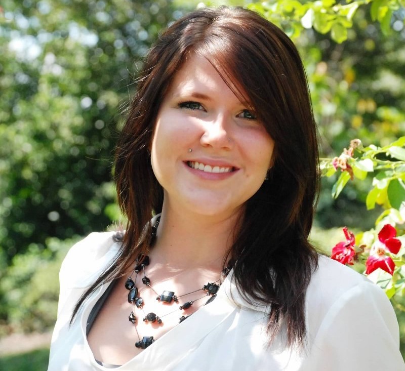 Christine Gartner, outside headshot of smiling woman with long brown hair, tiered necklace, and white shirt