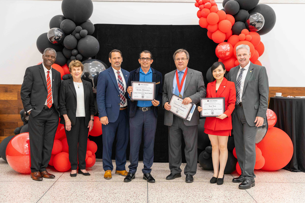 2026 Professor and Merit recipients and presenters, 7 men and women standing in front of red and black balloons