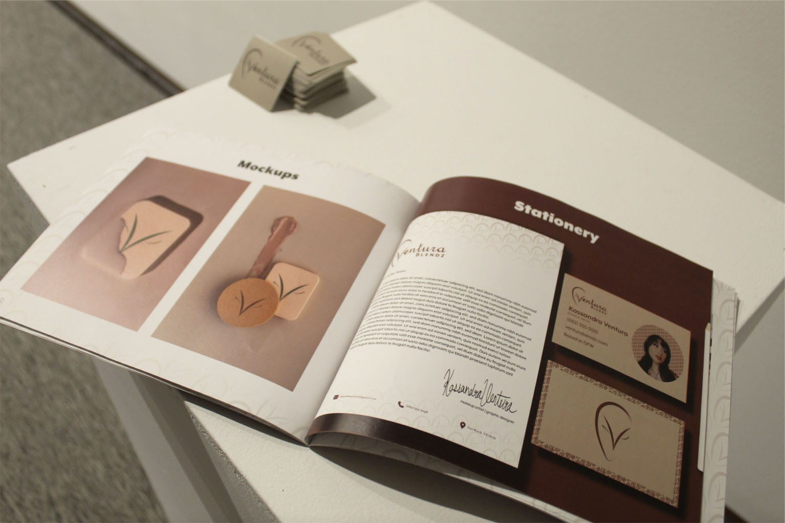 An open magazine displaying mockups and stationery designs on a white surface.