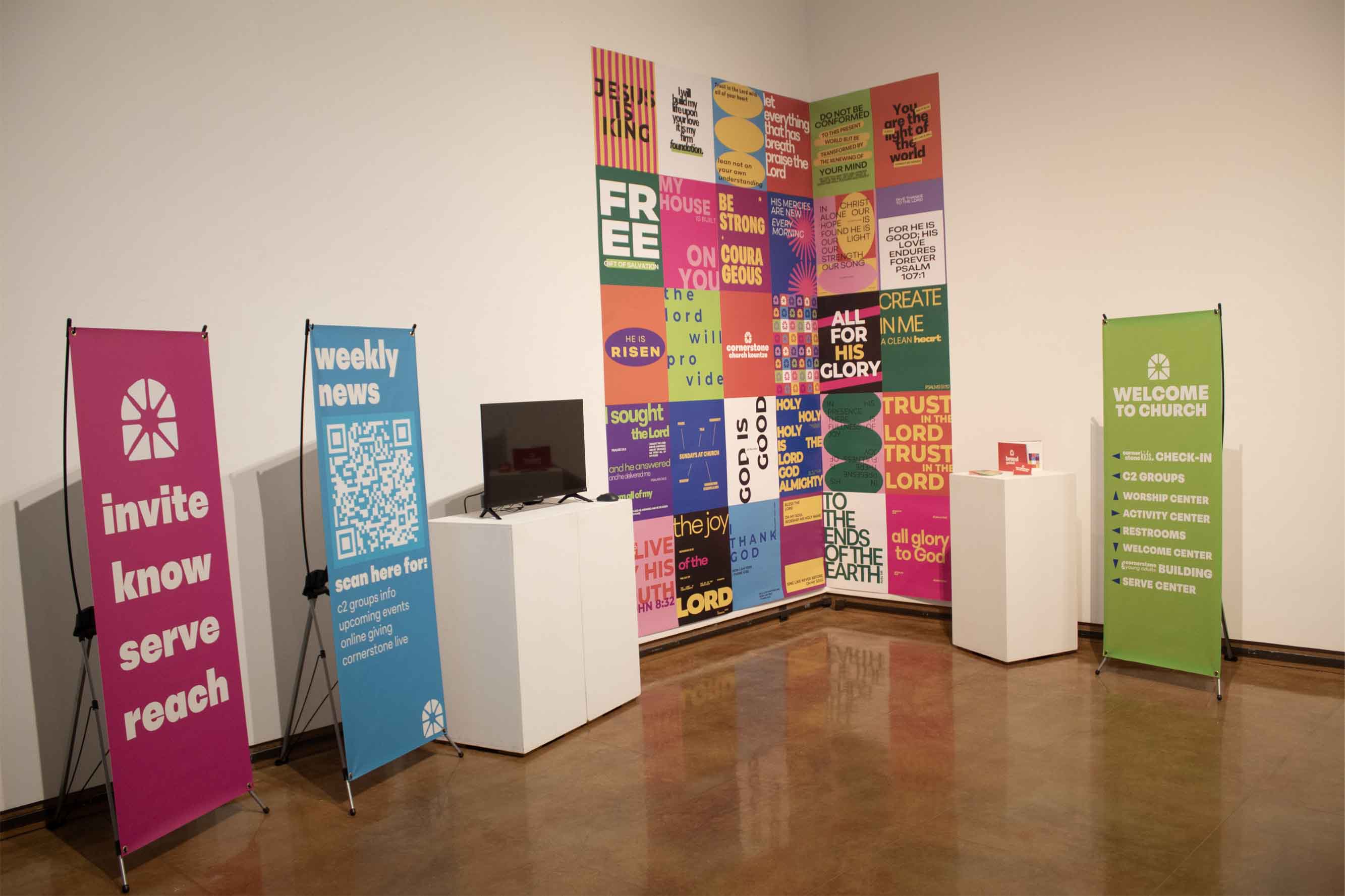 Room with colorful banners, a TV monitor, and a wall of inspirational text posters.