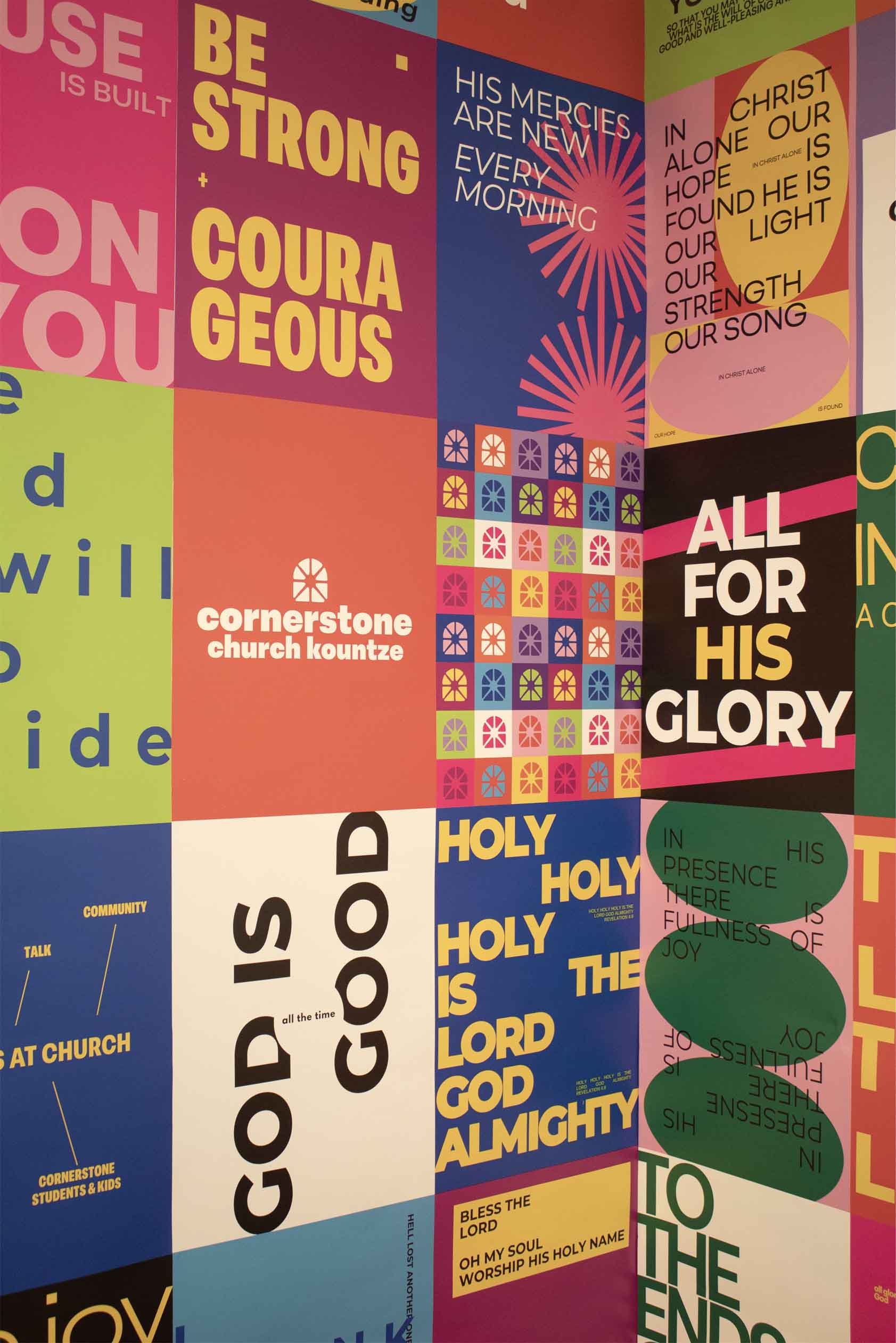 A colorful inspirational mural with religious text and decorative graphic elements.