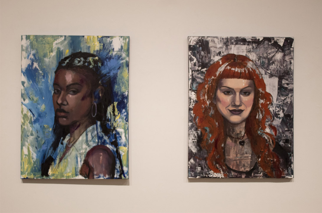 Two vibrant portrait paintings hanging side by side on a wall.