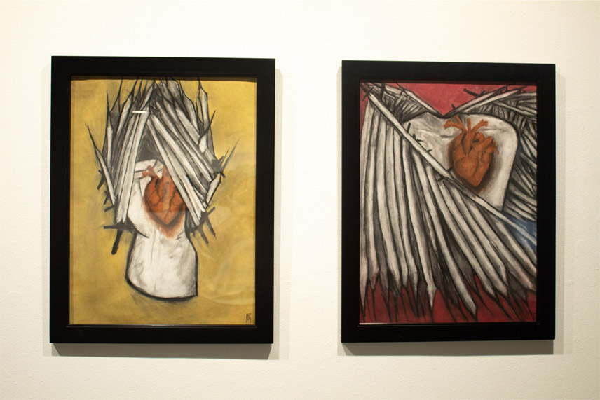 Two framed artworks showing hearts with feather-like wings on yellow and red backgrounds.