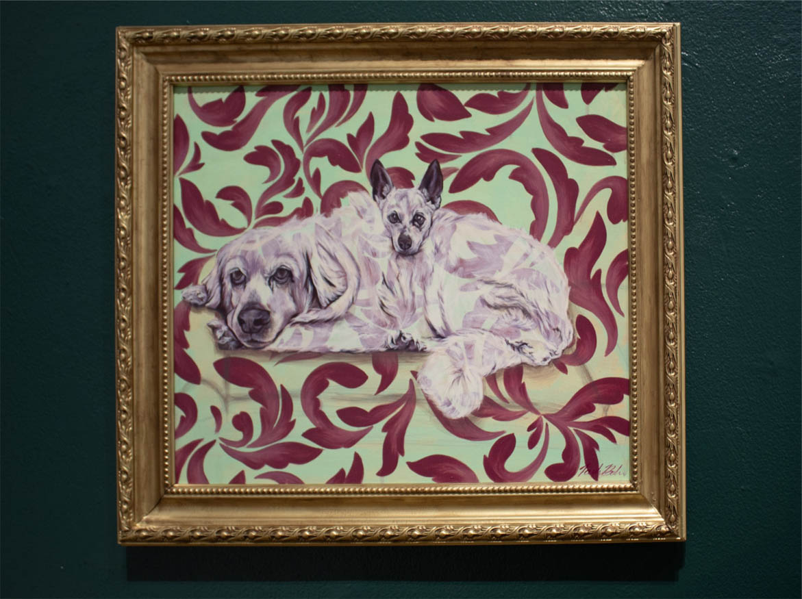 Painting of two dogs on a maroon patterned, light green background in a gold frame.