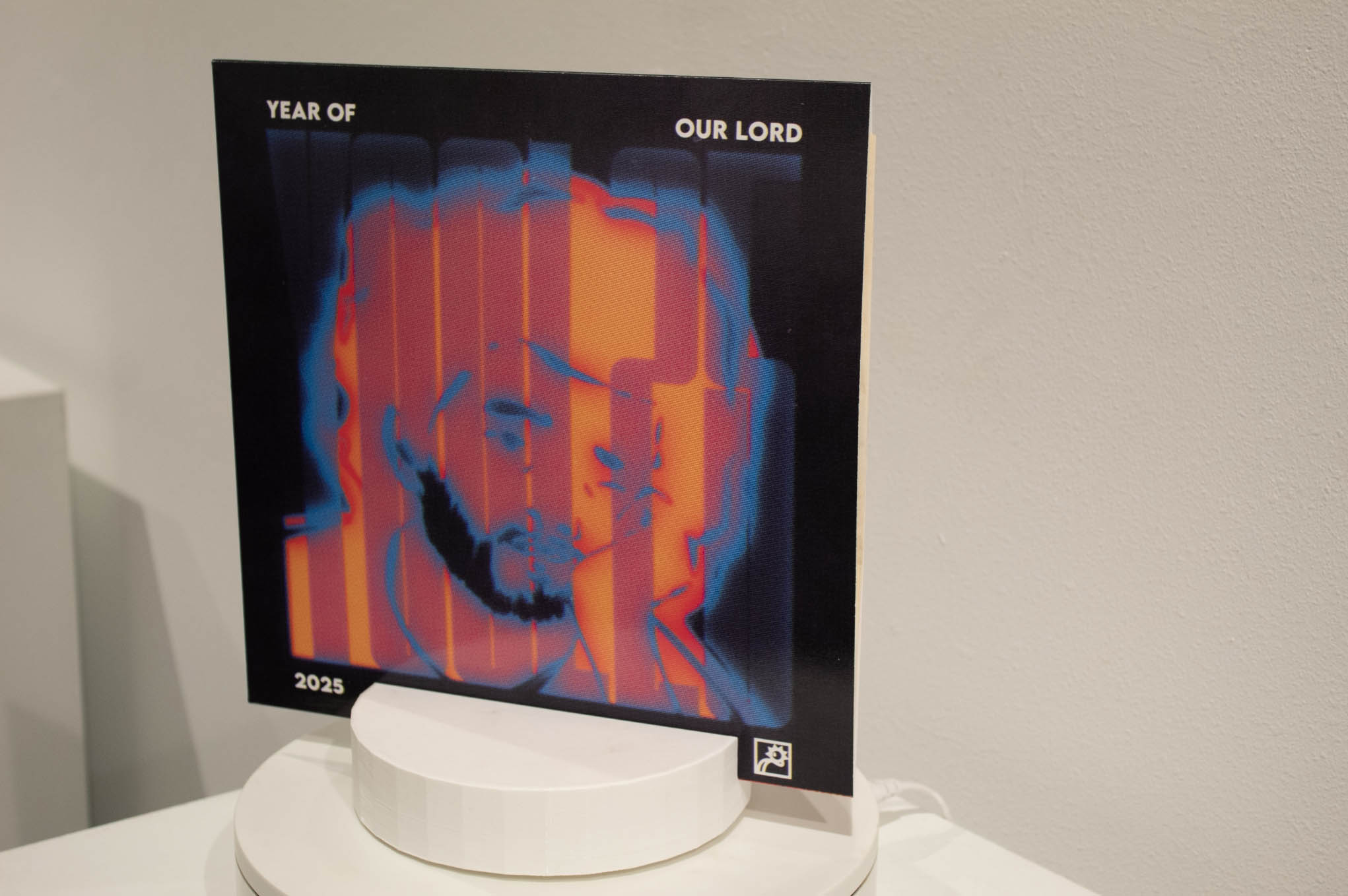Poster with an abstract image of a man's face in blue, orange, and red, and the text "YEAR OF OUR LORD 2025".