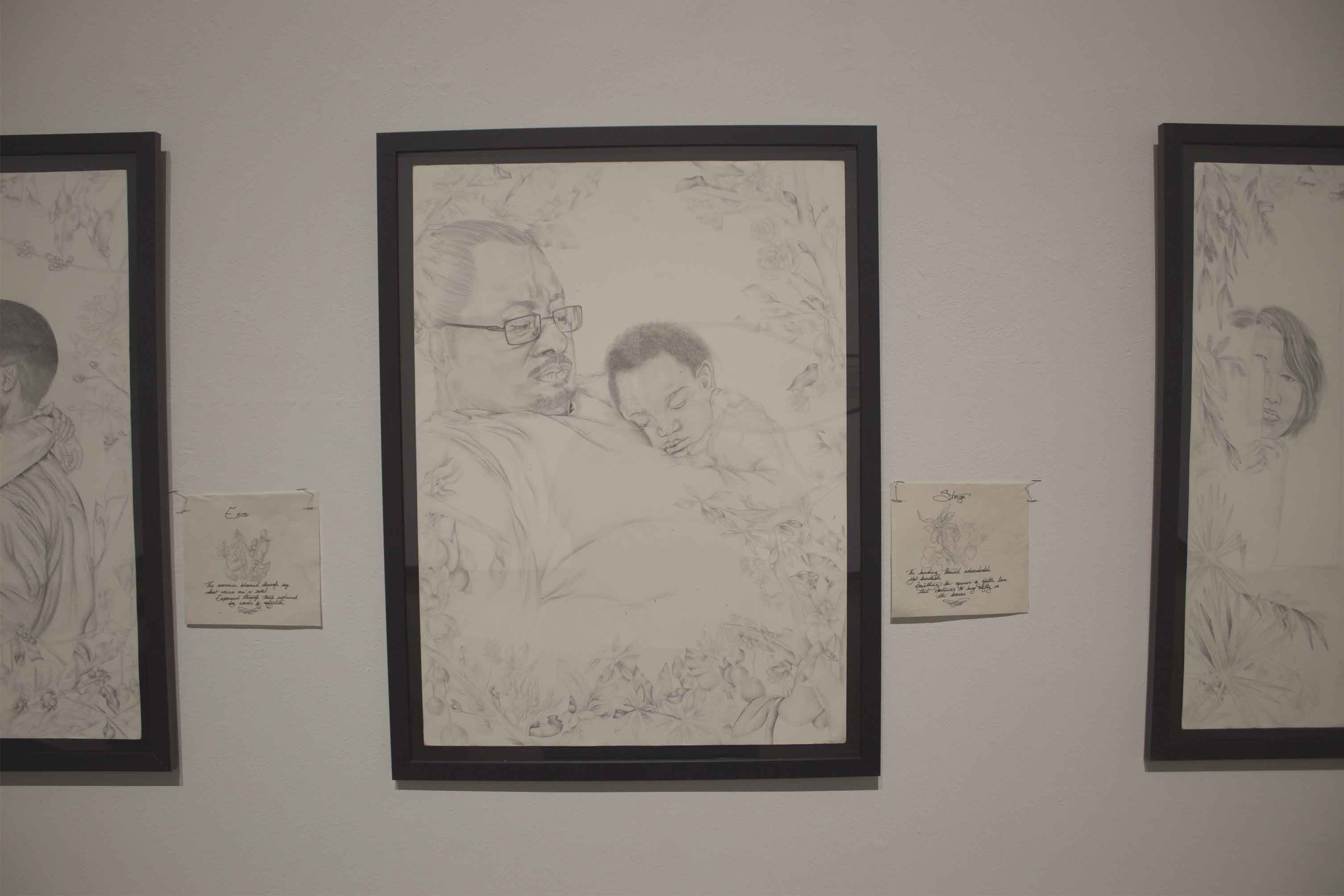 Drawing of a man with glasses holding a sleeping child, surrounded by flowers.