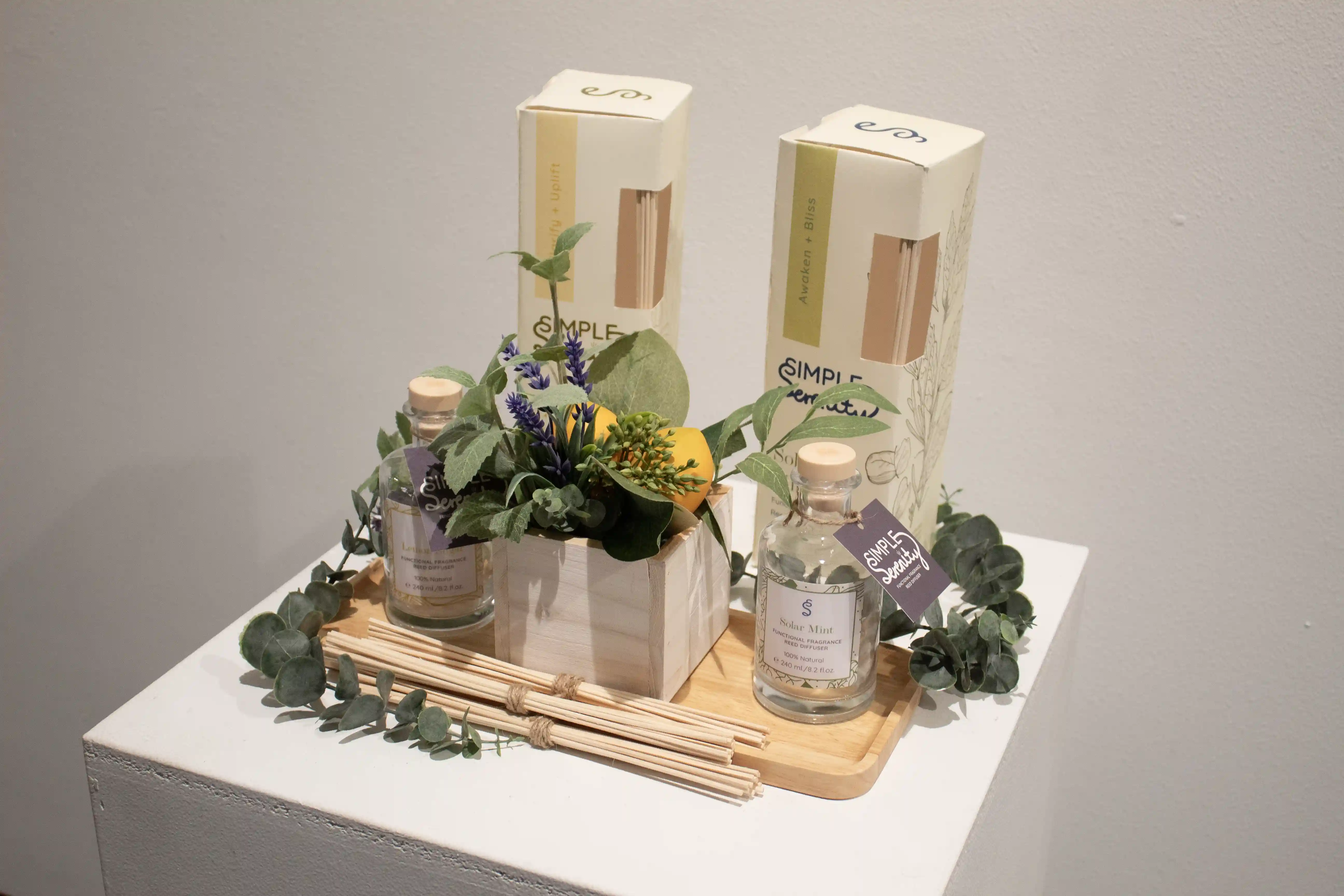 Simple Serenity - table showcasing product with diffuser reeds, jars, and product box