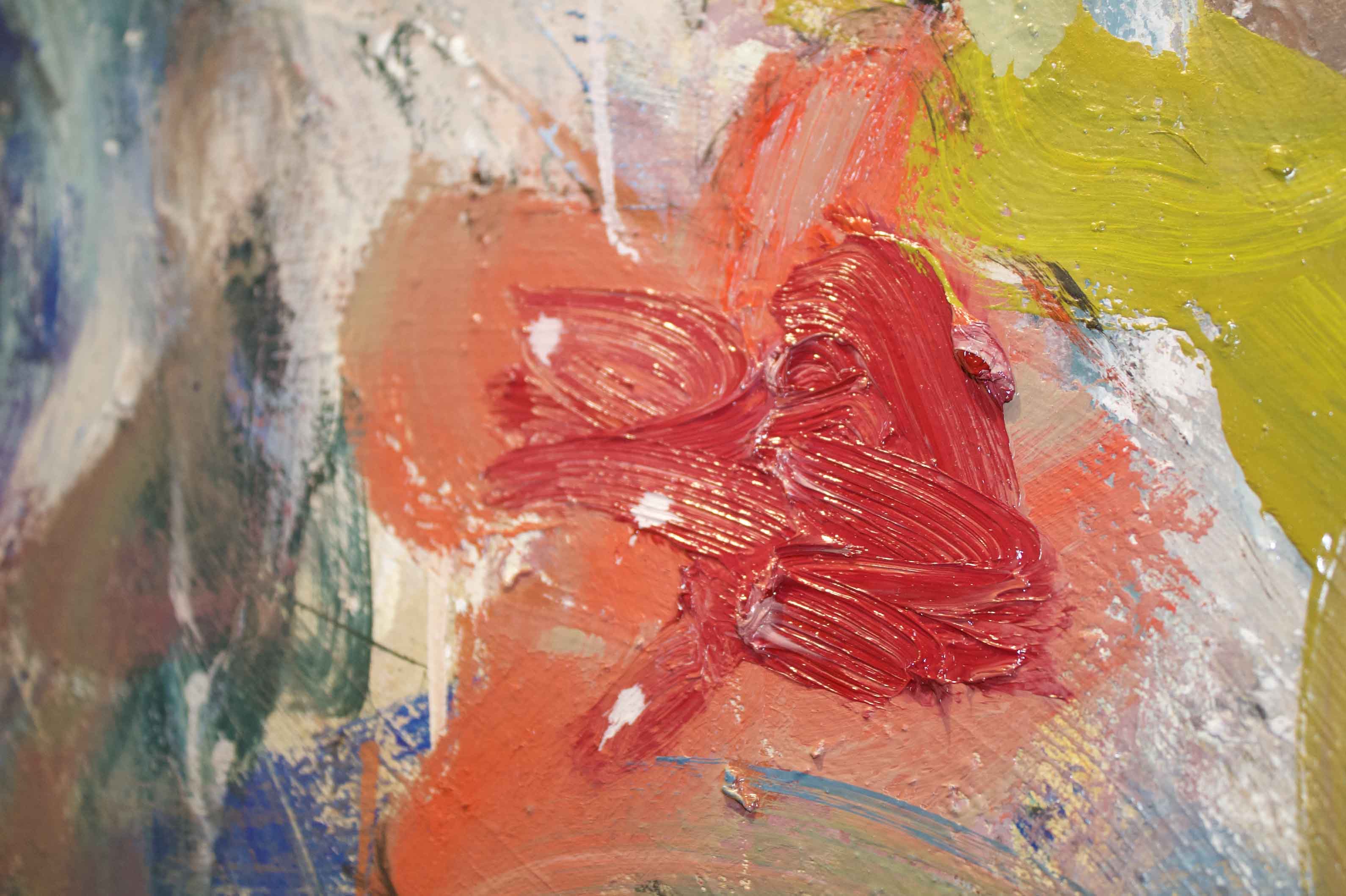 Close-up of an abstract painting with red, green, peach, and blue colors.