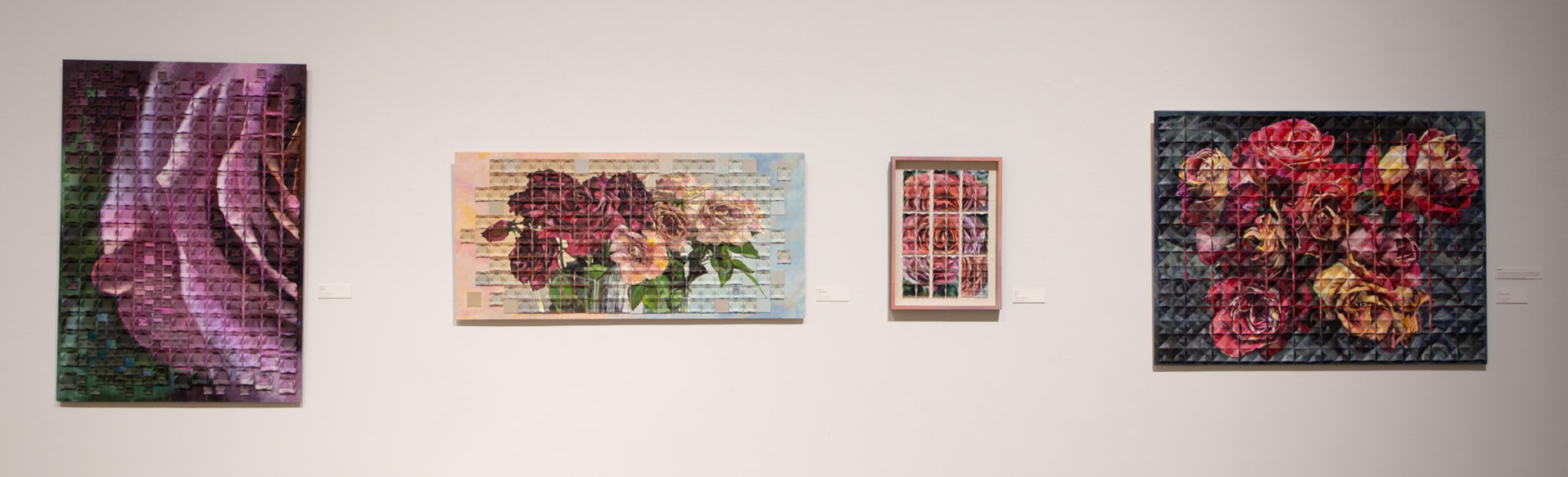 Four framed floral artworks on a gallery wall, each with a grid-like, mosaic design.