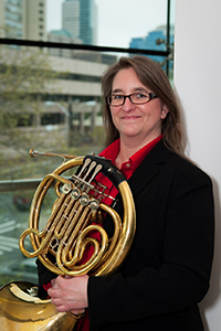 cathryn-cummings, woman smiling holding french horn