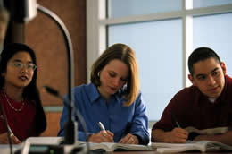 Students listening to lecture and taking notes in a classroom.