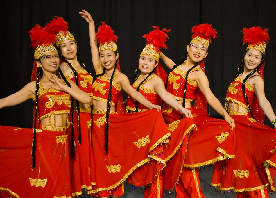 Chinese Cultural Dancers dressed in red and gold costumes with feather headdresses