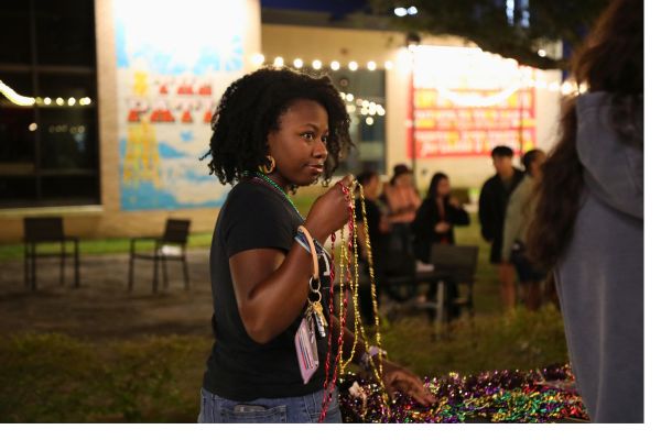 Student Holding Mardi Gras Beads