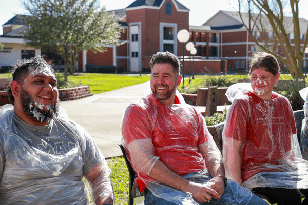 Faculty smiling at Pie a Professor Event