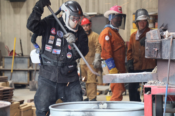 Faculty member preparing to remove smelted iron