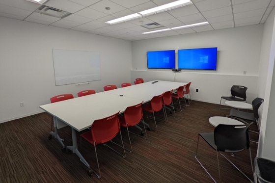 Cedar room setup conference style facing video conference screens