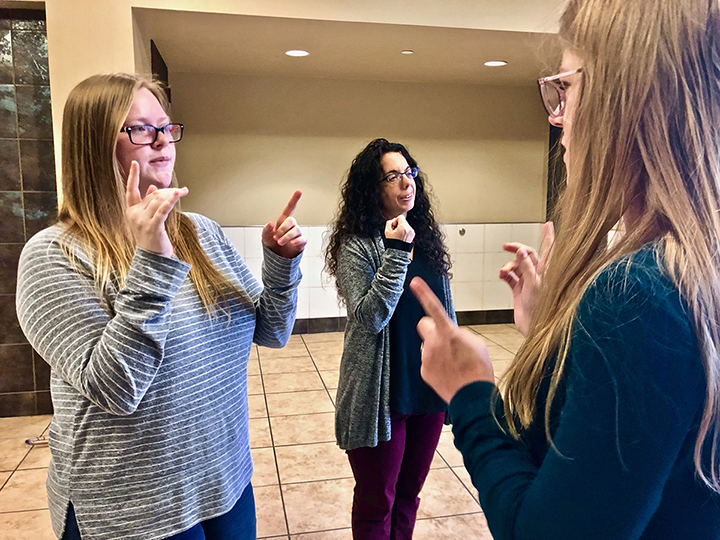 Reagan Brooks, left, and Erica Haase, right, and Amber Marchut, deaf studies and deaf education assistant professor, middle, converse in ASL, in the Communications Building, Nov. 19. UP photo by Vy Nguyen