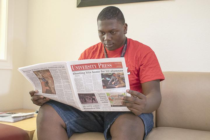 Daniel Johnson, Beaumont freshman, reads a copy of the University Press in the lobby of Gentry Hall, Sunday. UP photo by Caden Moran