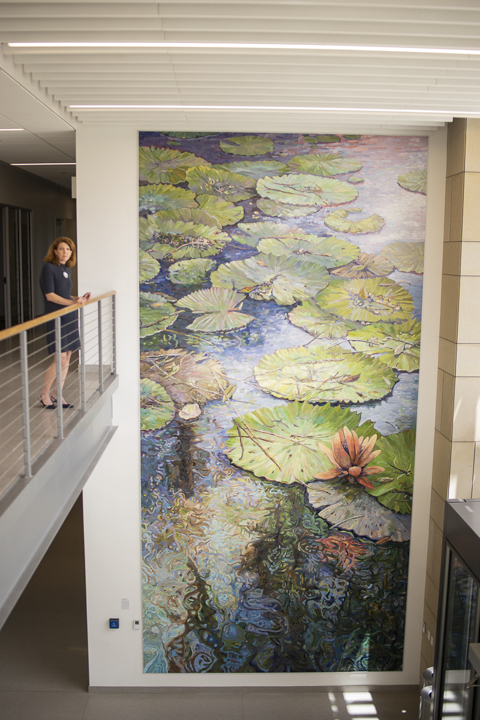 Kim Steinhagen, co-chair of Lamar’s Public Art Committee, above, stands next to the 25 feet by 12 feet mosaic mural by Dixie Friend Gay, in the Science and Technology building. UP photos by Noah Dawlearn