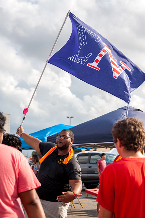 A member of Sigma Nu proudly waves his fraternity flag as they prepare for the night’s homecoming game at the Provost Umphrey Stadium. UP Photo by Delicia Rocha