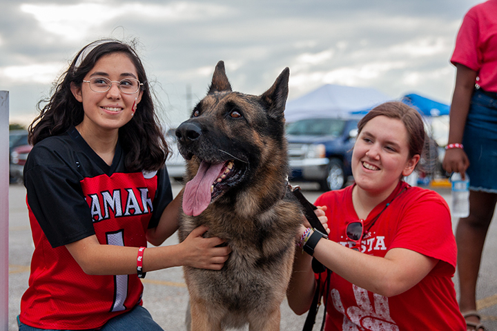 LU students pet a German-Shepherd as they wait for the night’s homecoming game at the Provost Umphrey Stadium. UP Photo by Delicia Rocha