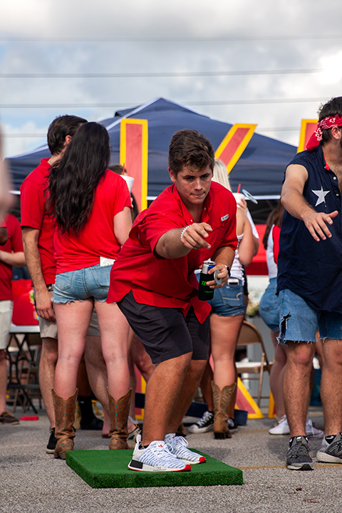 Member of a fraternity plays a round of washer toss during tailgating at the Provost Umphrey Stadium. UP Photo by Delicia Rocha