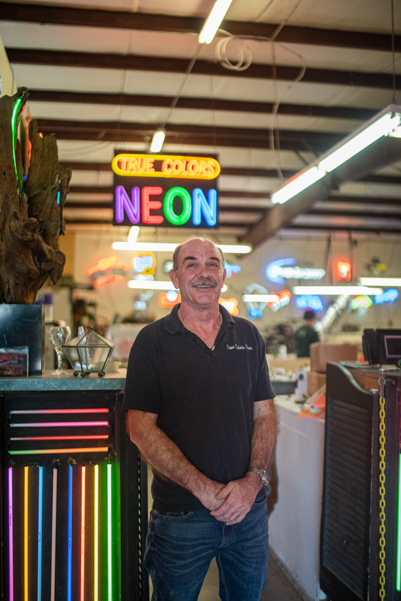 Dobelmann stands in front of the entrance to his shop, next to a test kit of the diffrent types of neon his shop provides near Richmond Ave. in Houston, Oct. 18. 