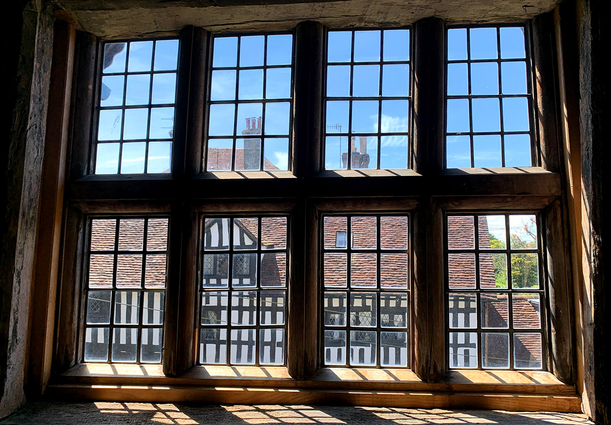 The exterior of the Anne of Cleves House, left, can be seen through the windows of an adjacent building exhibiting more artifacts of the time.