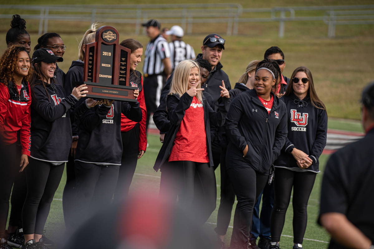 The Lamar University women's soccer team rises the championship trophy during the football game at Provet Umphrey Stadium on Nov 2. UP photo by Noah Dawlearn