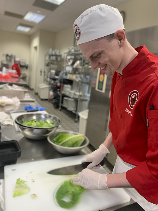 Philip Parsons, Anahuac junior, right, prepares a meal for the Cardinals on the Run meal program, Monday. UP photo by Christina Segura
