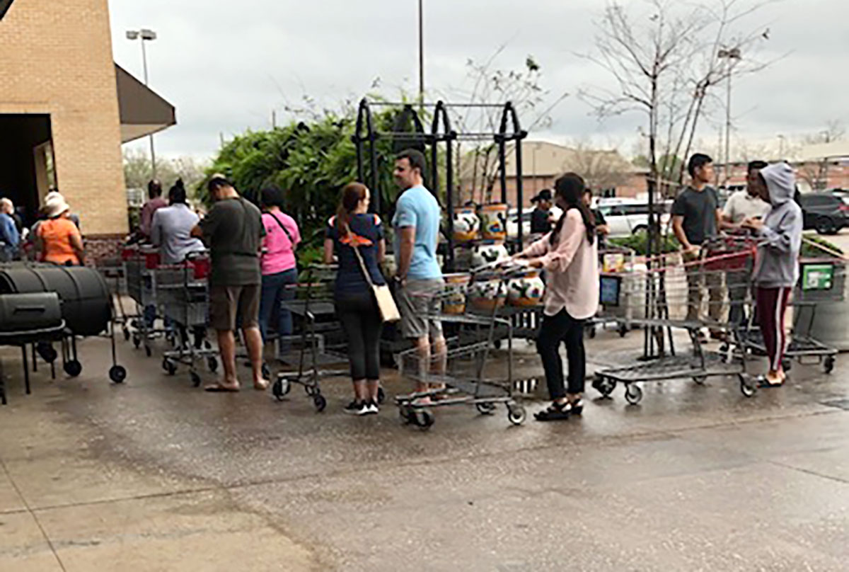 Customers wait in line outside HEB in Missouri City