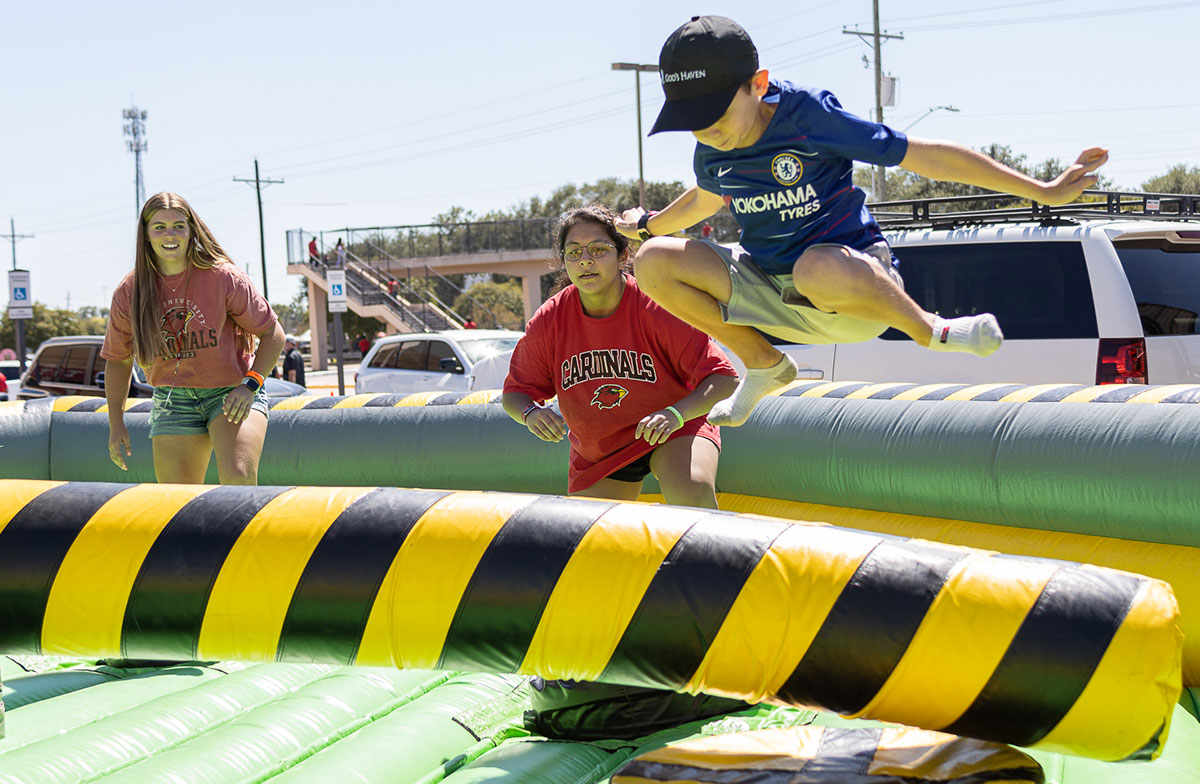 A child leaps over a rotating bar during the Homecoming tailgate at the Montagne Center parking lot, Oct. 1. UP photo by Brian Quijada.