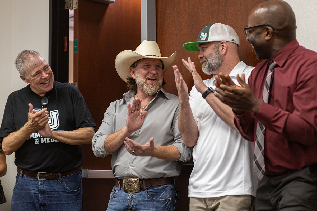 Communications and media instructor Jeremy Hawa claps with faculty and staff after being recognized at the COMM-Unity event in the Communications Building, Aug. 22. UP photo by Brian Quijada.