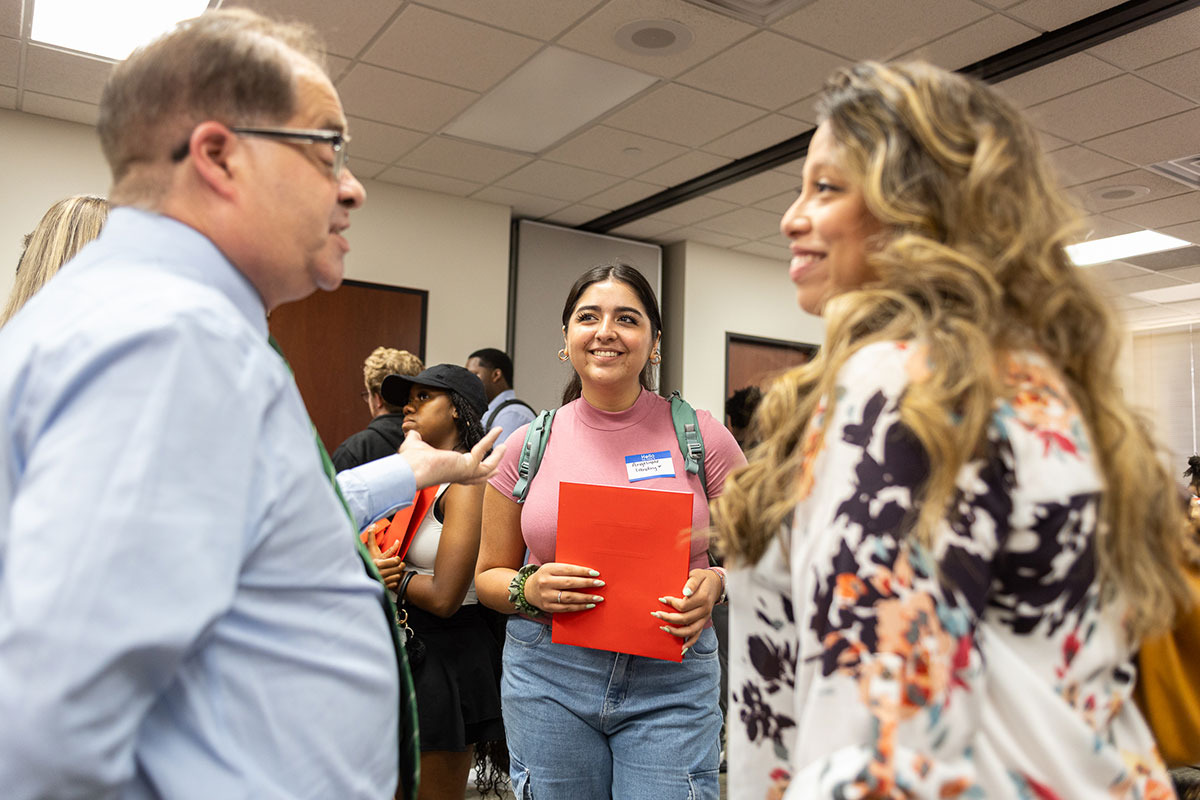 Angel San Juan (left) and staff speak to a student at the COMM-Unity event in the Communications Building, Aug. 22. UP photo by Brian Quijada.