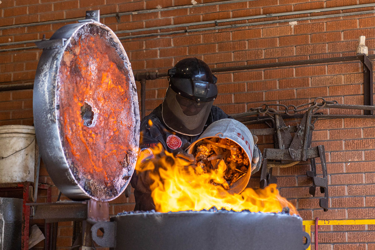 Lamar art professor Kurt Dyrhaug dumps the pieces of iron into the furnace, March 3, at the art foundry. UP photo by Brian Quijada.