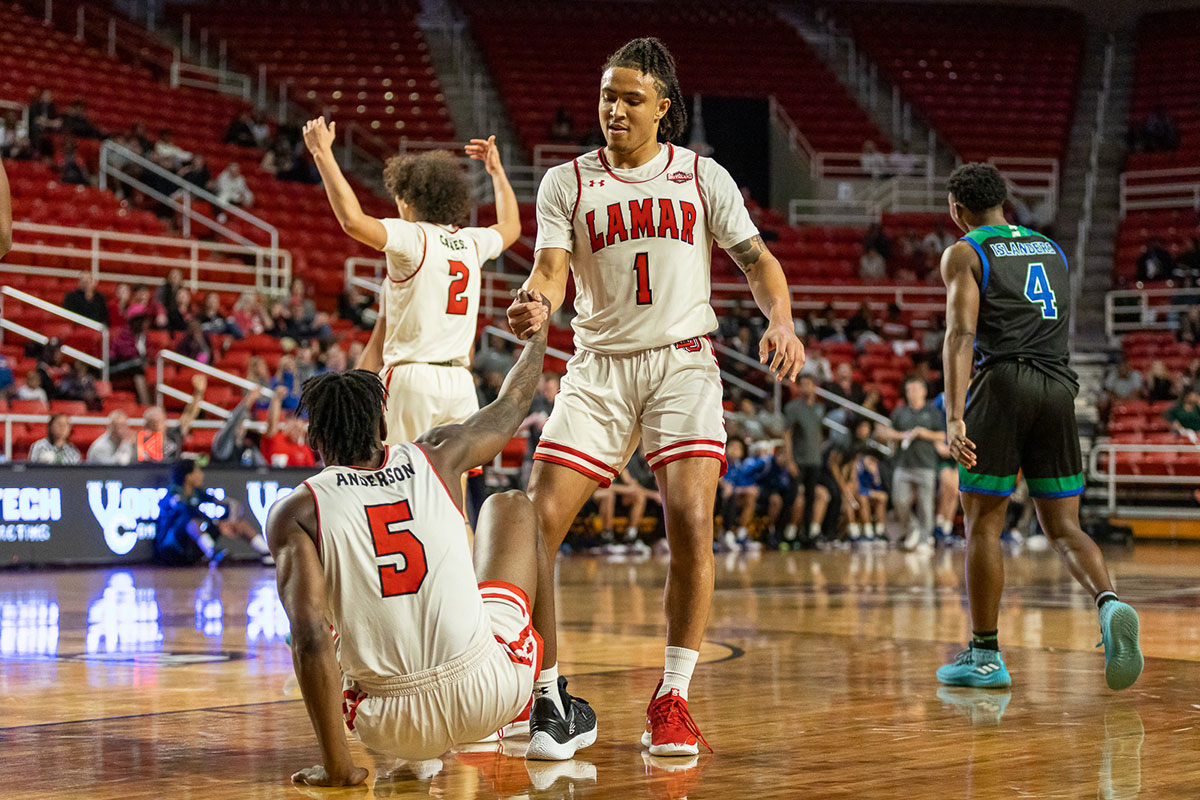 Freshman guard Brian Gordon helps his teammate get up, Terry Anderson, after being fouled by the Islanders, Jan 19, at the Montagne Center. UP image by Brian Quijada.