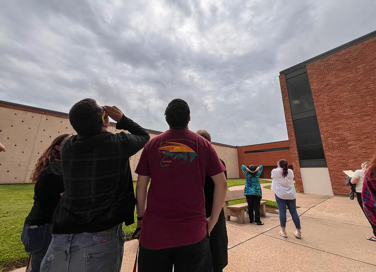 Students and staff look for the solar eclipse in the overcast sky at Lamar University, April 8. UP photo by Taylor Justice.
