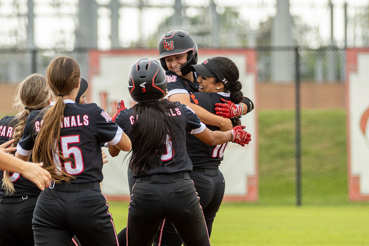 Davis was mobbed by her teammates, left, as Lamar beat the University of Incarnate Word 5-4 in Southland Conference action. UP photo by Brian Quijada.