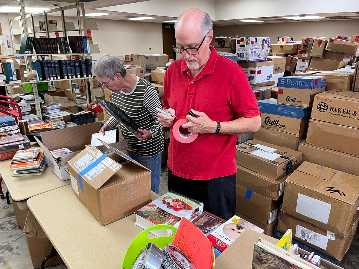 Elaine Wikstrom, left, and Phil Kauper sort through boxes ahead of the Friends of the Beaumont Public Libary’s $2 Sack of Books sale, set for April 5-6. UP photo by Aaron Saenz.